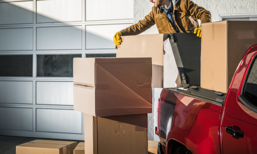 Man putting cardboard boxes in the back of his truck