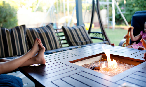 Feet resting on an outdoor patio fireplace